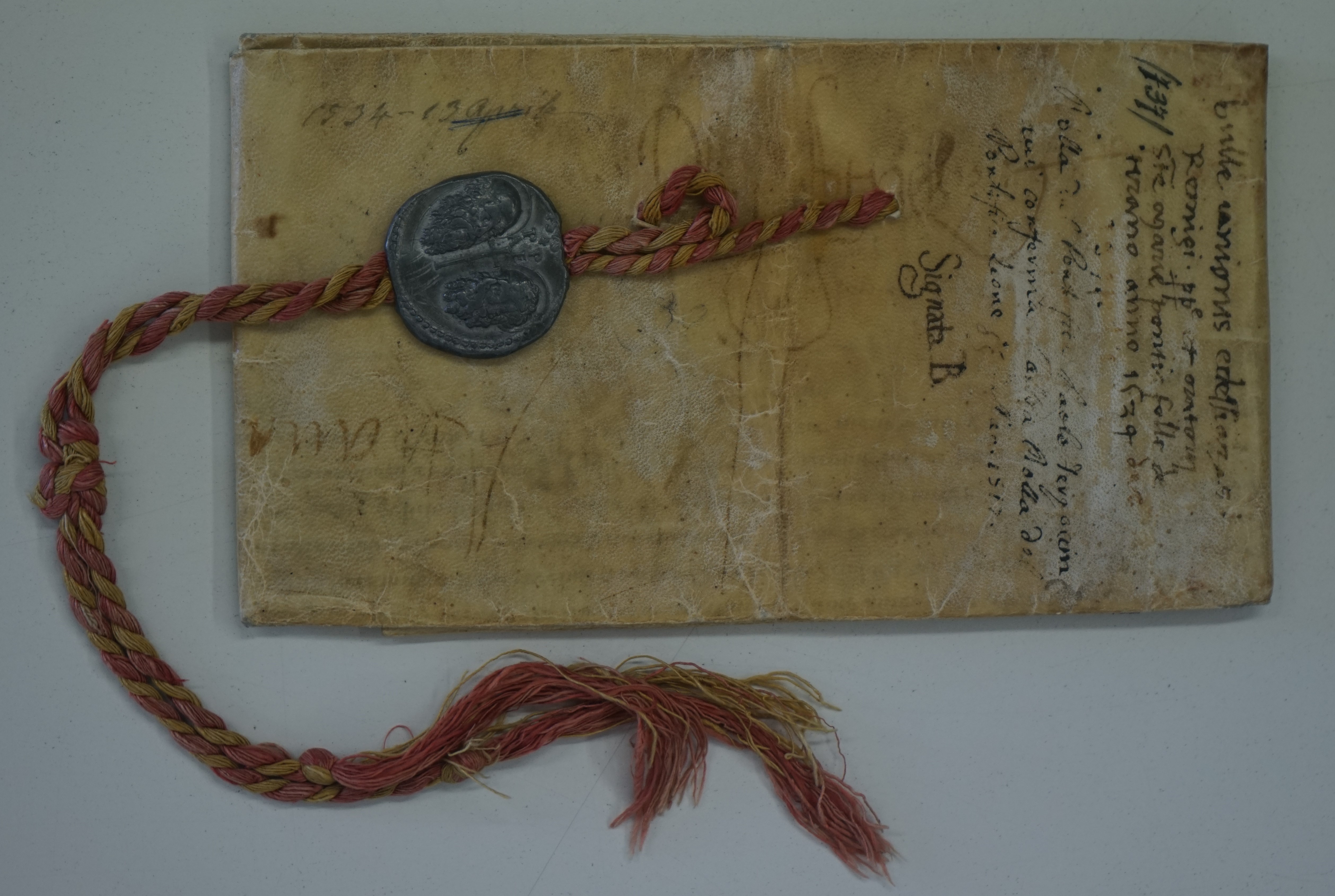 Bolla di Papa Paolo III datata 27 settembre 1517 con cui si conferma l’annessione al
Santuario della Madonna di Tirano di tutti i beni delle chiese di S. Remigio e di S. Perpetua
nonché degli ospedali dei poveri o luoghi pii ad esse collegati. Sigillo pendente integro, con
corda in seta bicolore gialla e rossa.